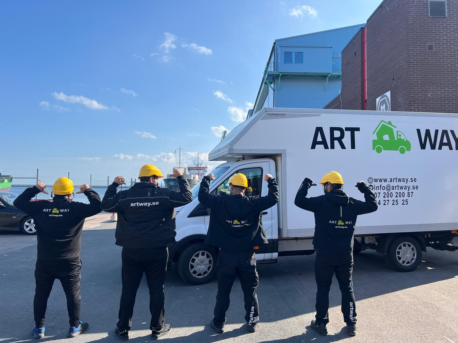 Fyra Artway-medarbetare i arbetskläder framför en profilerad flyttbil
