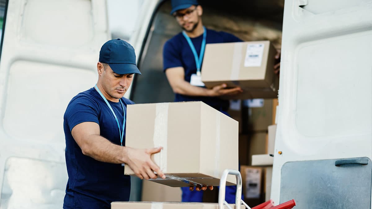 Movers handling boxes beside a moving van